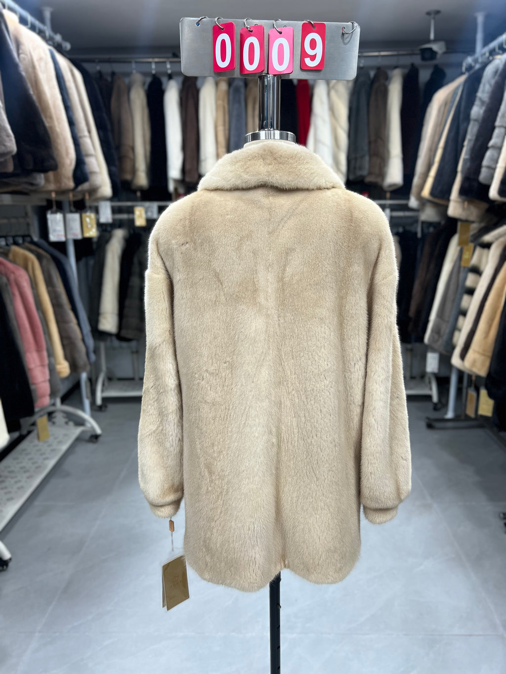 Beige velvet-finish mink coat featuring a lapel collar, horizontal pocket flaps, and vintage-style button detailing.009