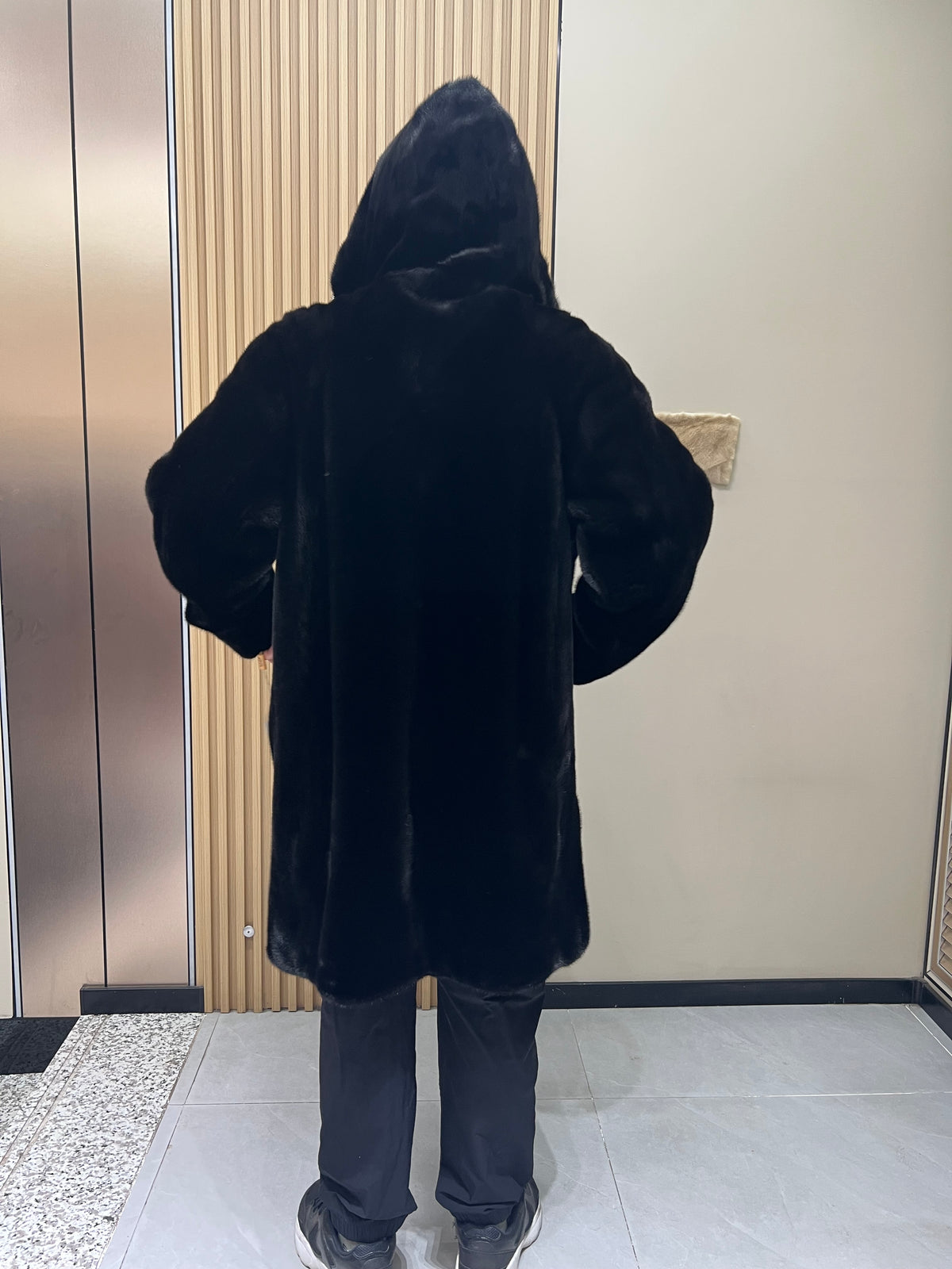 No. 128 Men's black long-length hooded mink coat with front zip closure.