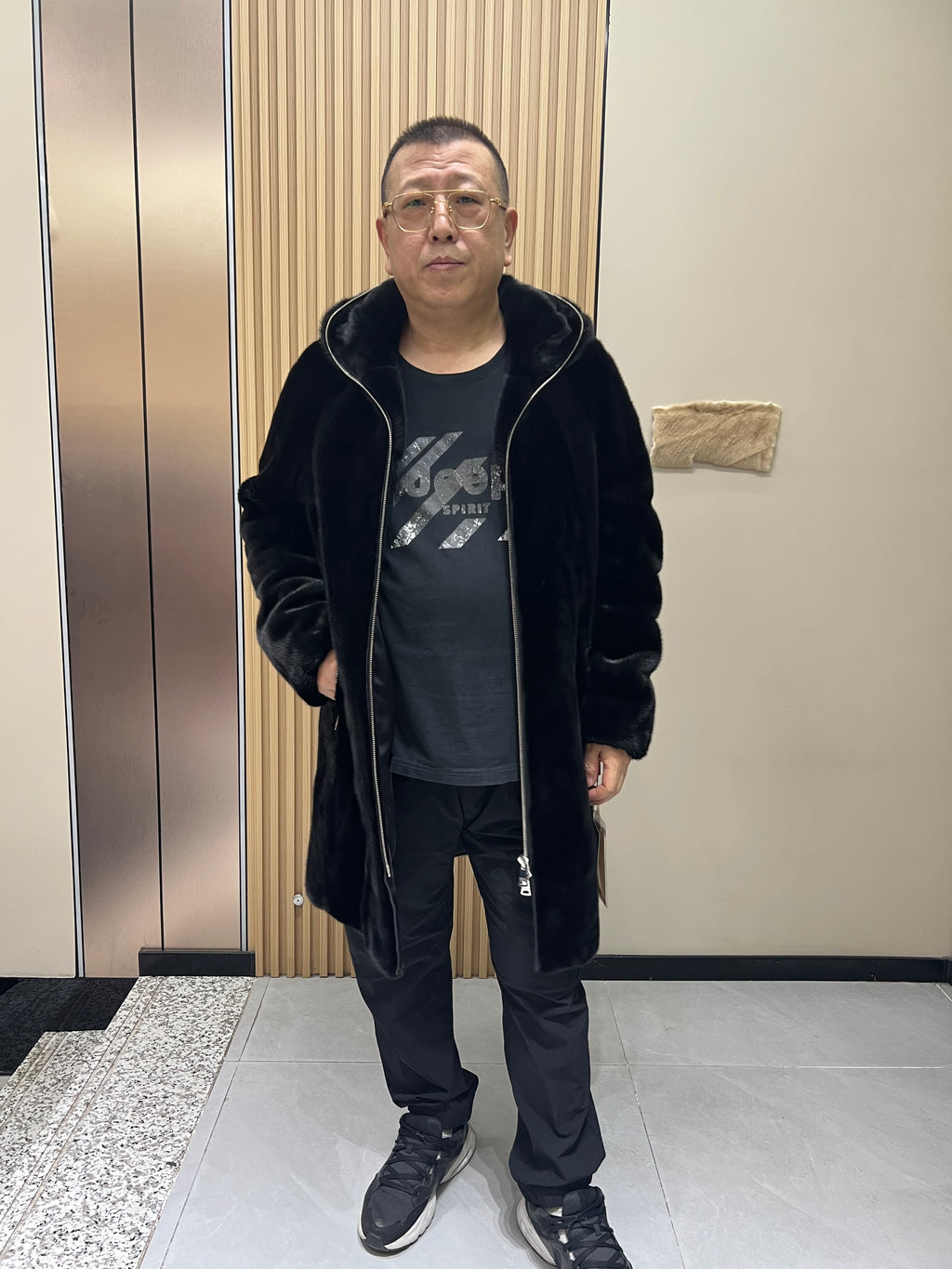 No. 128 Men's black long-length hooded mink coat with front zip closure.