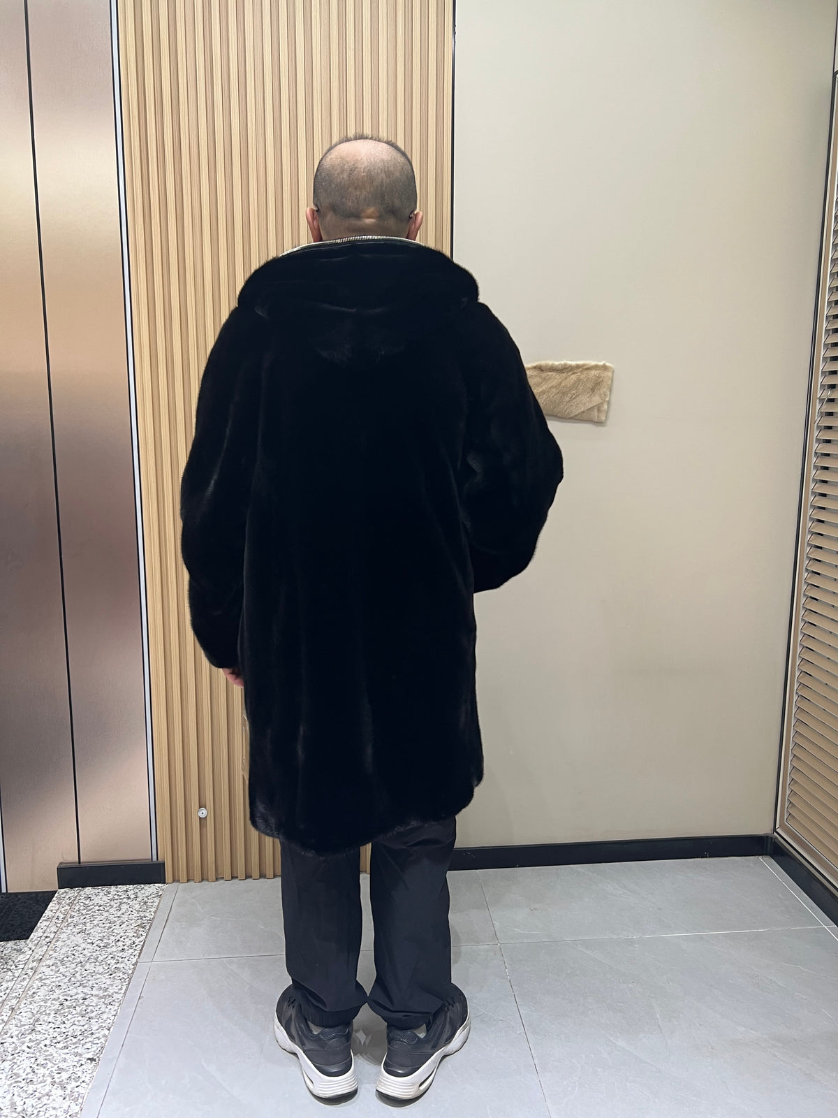 No. 128 Men's black long-length hooded mink coat with front zip closure.
